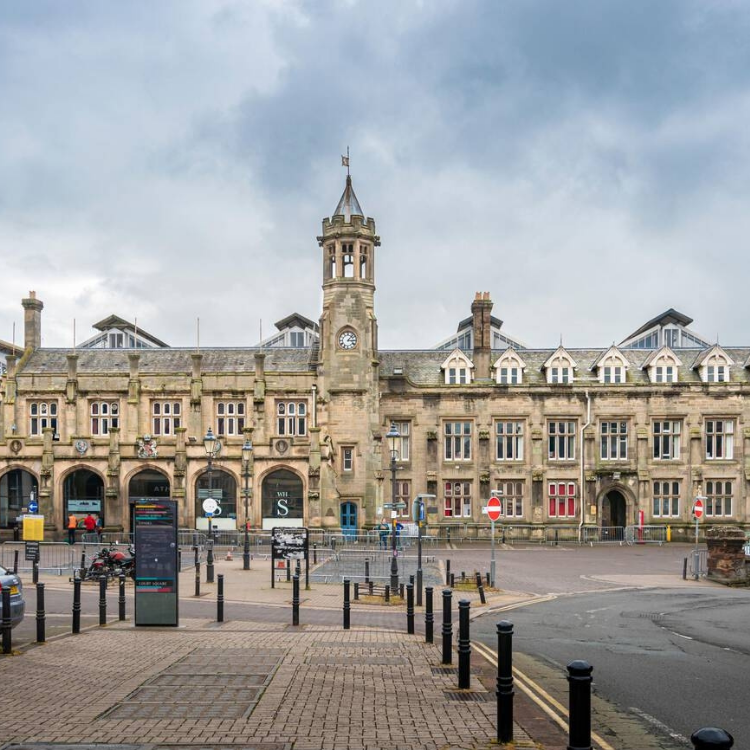 Exterior view of Carlisle Train Station Building, showcasing its historical architecture and bustling activity