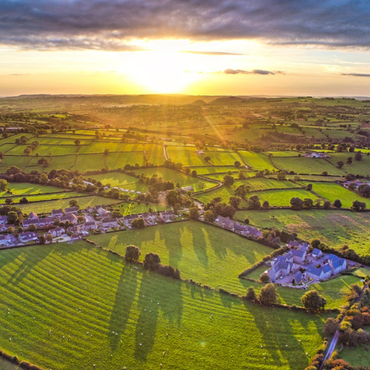 Aerial view of Ashbourne in Derbyshire capturing the town's landscape just as the sun is about to set.