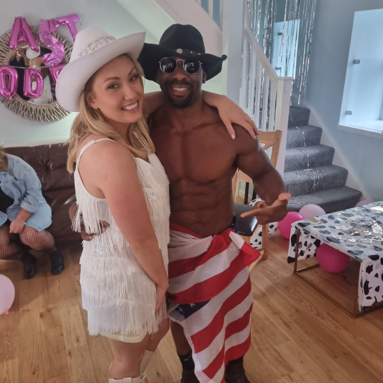 A male stripper in a cowboy hat posing with a bride-to-be at a hen party in Essex. Male Strippergrams