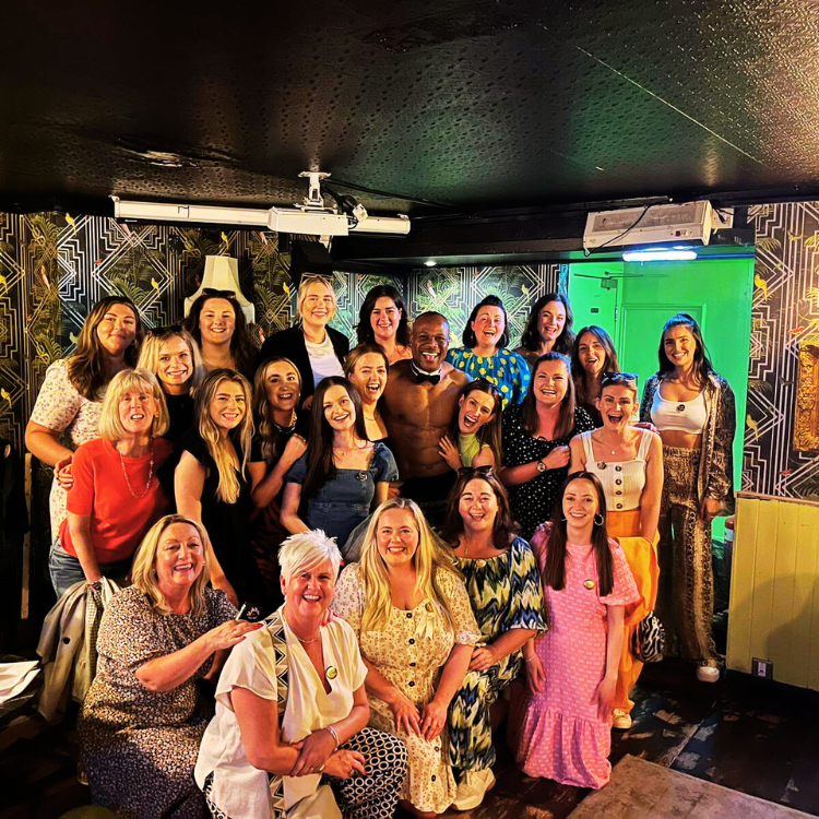 Group of joyful women posing with a life model at a Hen Party Life Drawing in Hersham. Best Hen Party Life Drawing in Hersham