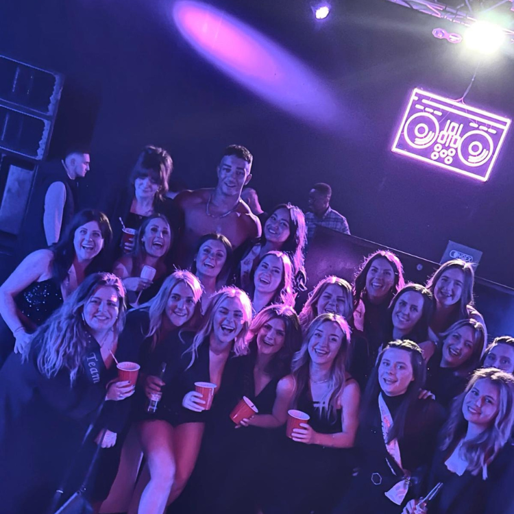 Male Strippers in Essex posing with a group of ladies after a ladies night performance. Male Strippergrams.