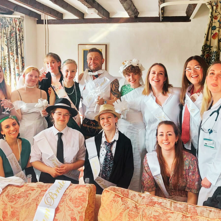 Naked Butlers in Glasgow humorously dressed in toilet rolls posing with the bride and her friends at a hen party game.