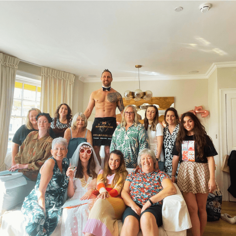 A buff butler at a hen party event with a group of girls