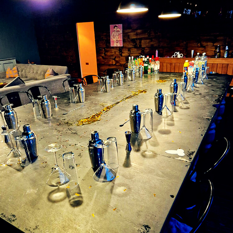 A well-organized table set with various cocktail glasses, shakers, and other mixology tools ready for a mobile cocktail making class